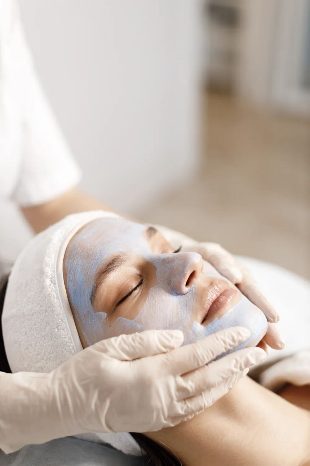 Cliente recebendo tratamento facial com máscara na clínica